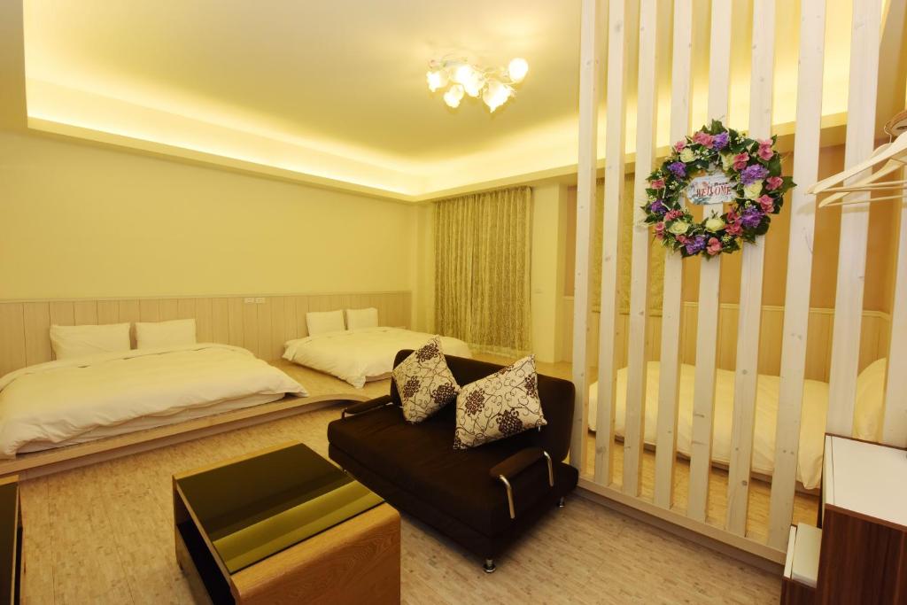 a bedroom with two beds and a couch and a wreath at GJia Taitung B&B in Taitung City