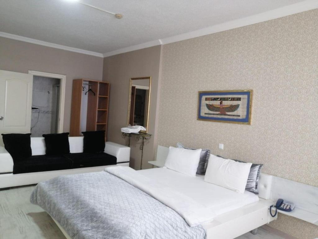 a bedroom with a large white bed and a couch at Masal Otel in Kocaeli