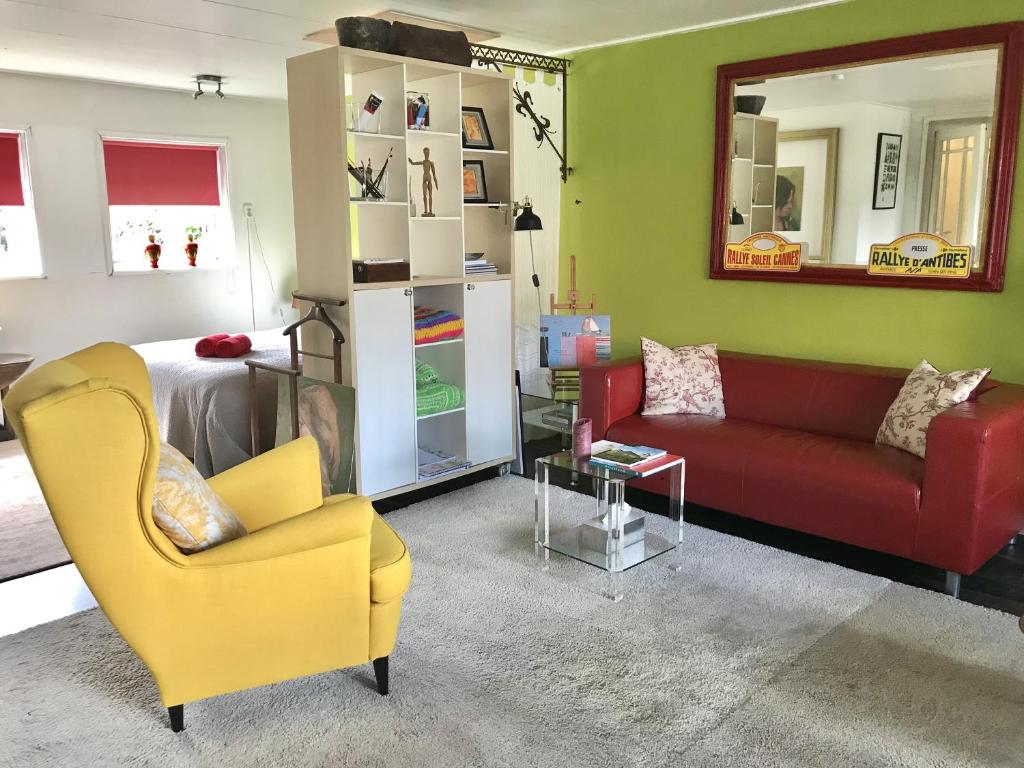 De Fryske Wyn في Ferwerd: غرفة معيشة مع أريكة حمراء وكرسي اصفر