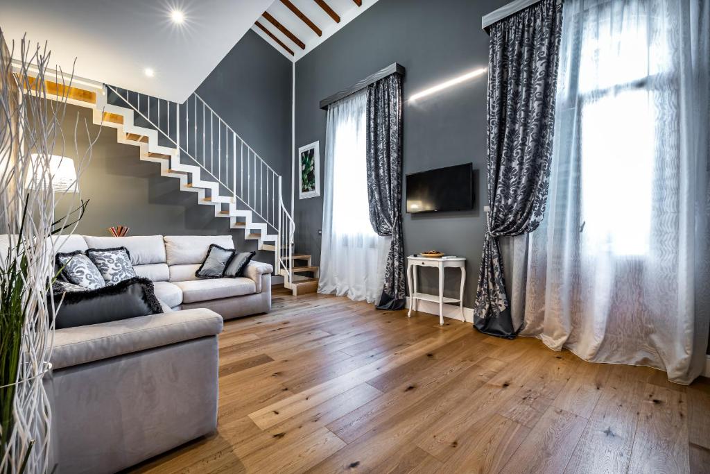 ein Wohnzimmer mit einem Sofa und einer Treppe in der Unterkunft YiD Capo di Mondo Luxury apartment in florence in Florenz