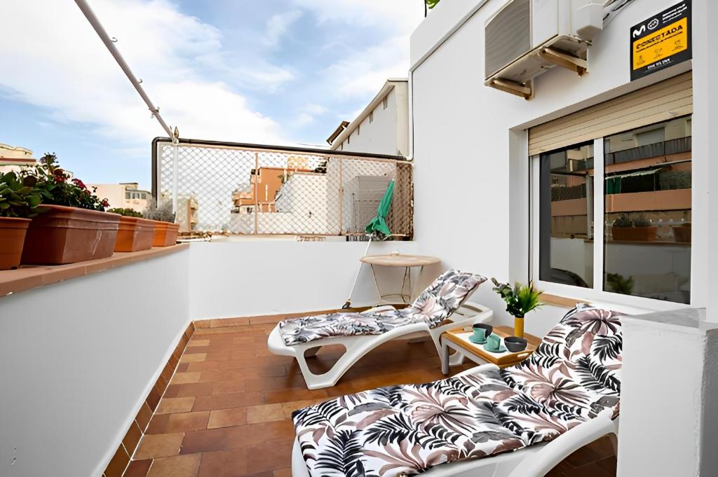 聖阿德里安德貝索斯的住宿－Terrace Apartment，阳台配有2把椅子和1张沙发