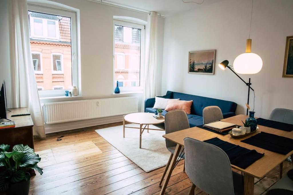 a living room with a blue couch and a table at Sanierter Altbau, 2 Zimmer, 24-7 Check-in in Kiel