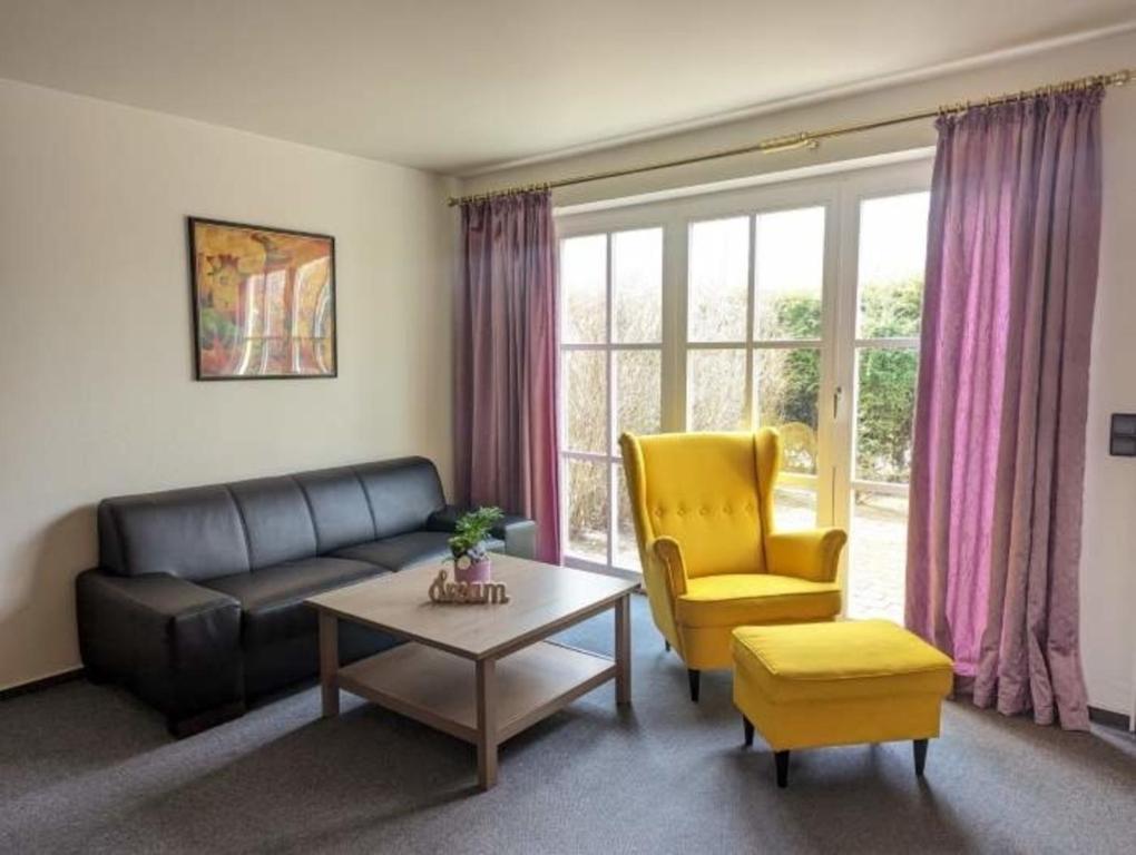 a living room with a couch and a chair and a table at Ruth Sonnenhut in Wulfen auf Fehmarn