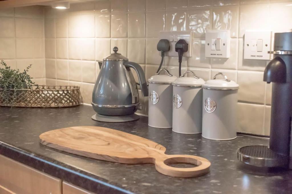 una encimera de cocina con una cuchara de madera en una encimera en Hibiscus House, en Shilton