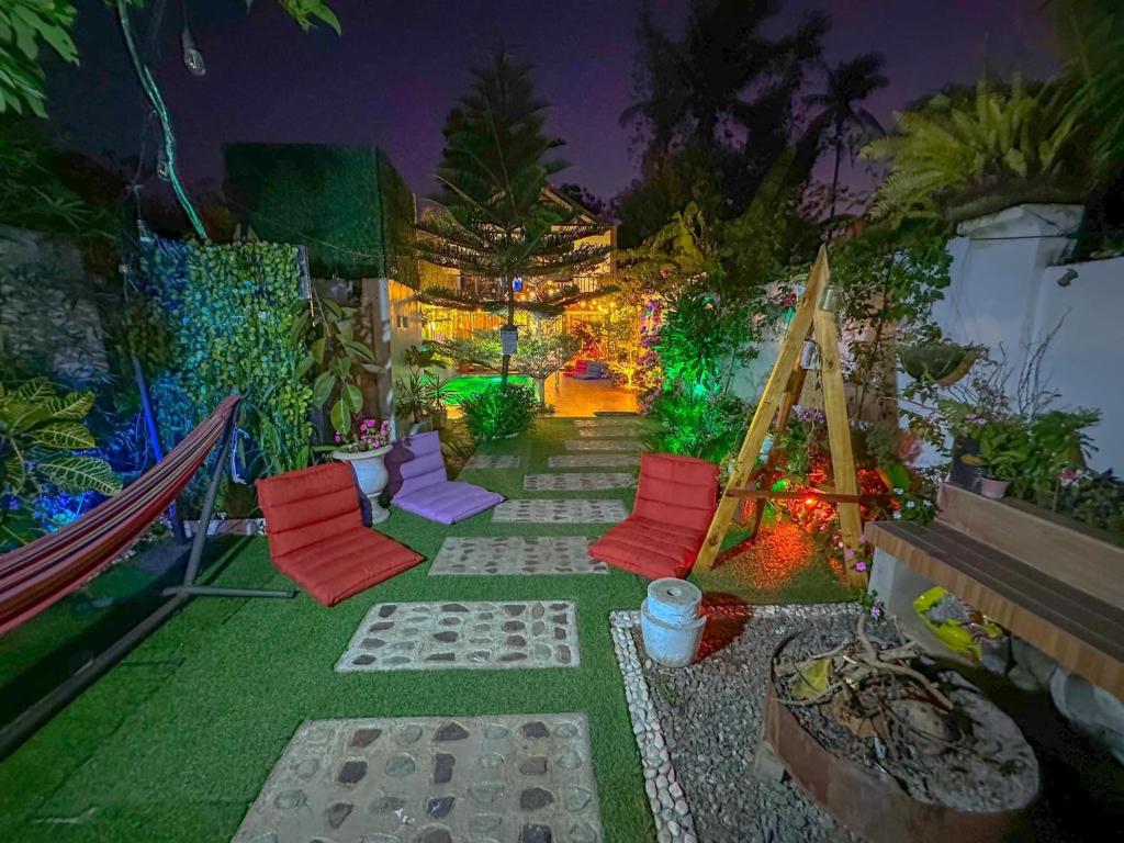 un patio con sillas rojas y luces por la noche en Remy's Nest en Tagaytay