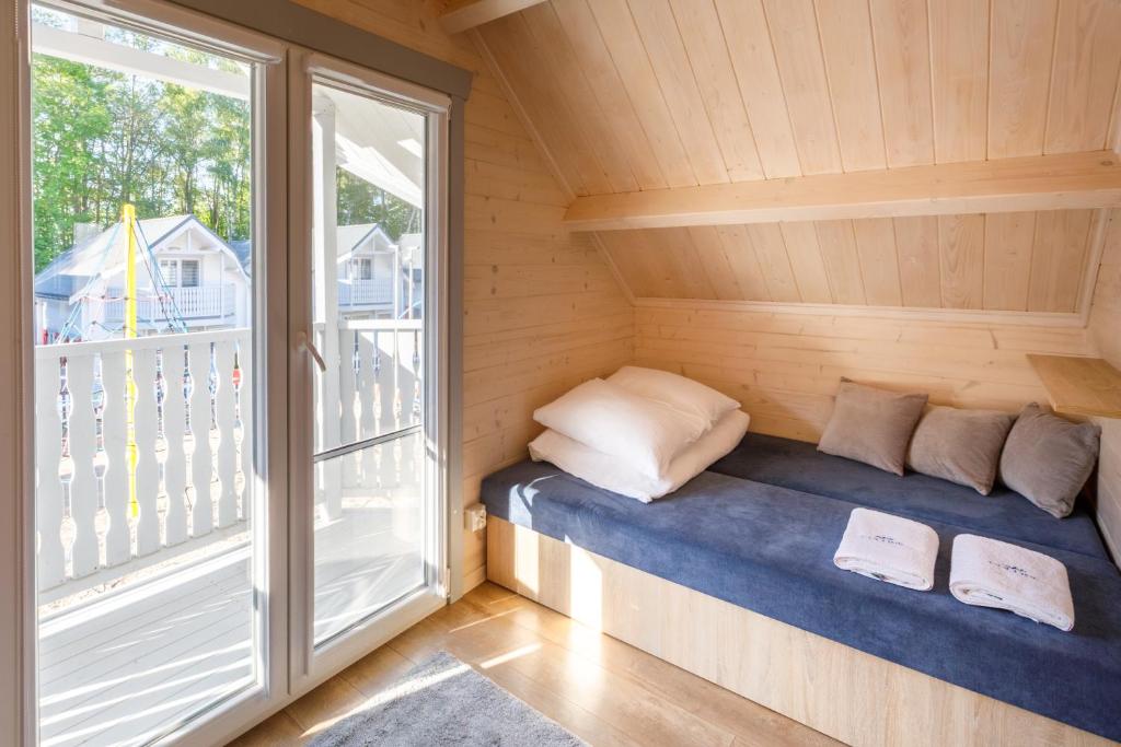 a small room with a bed in a sauna with a window at Collins Holiday in Ustronie Morskie
