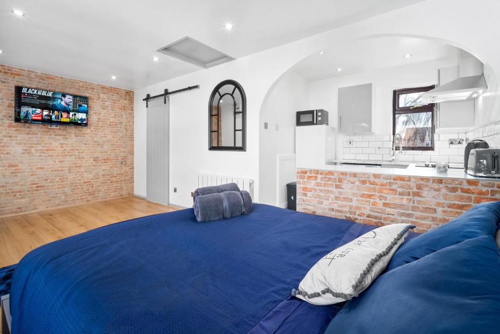 a bedroom with a blue bed and a brick wall at Luxury cosy apartment in Birmingham
