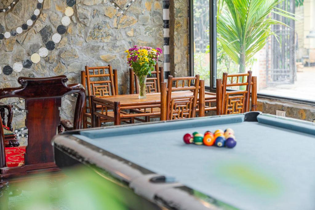 a pool table in a room with a table and chairs at Tam Coc Paradise Homestay in Ninh Binh