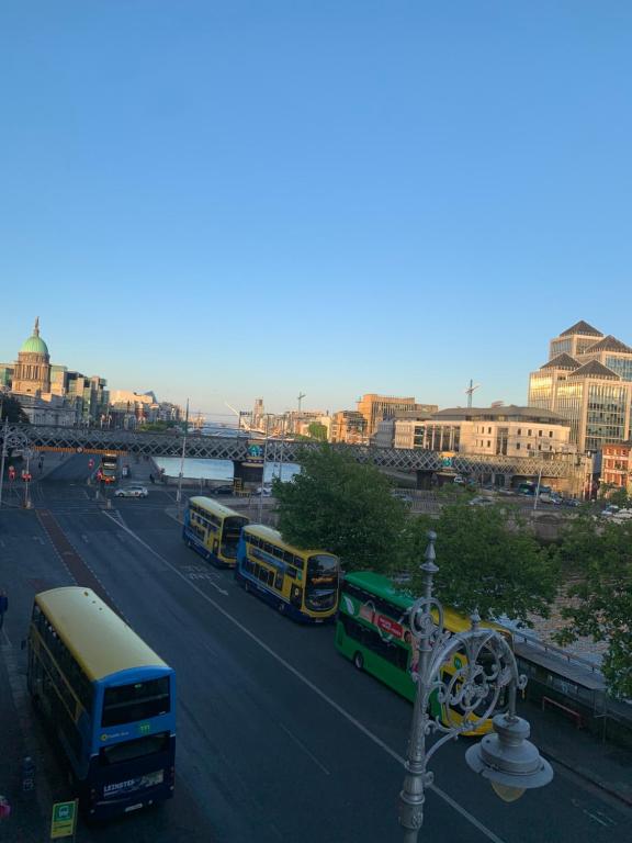 un grupo de autobuses conduciendo por una calle de la ciudad en City Centre Skyline Private Room, en Dublín
