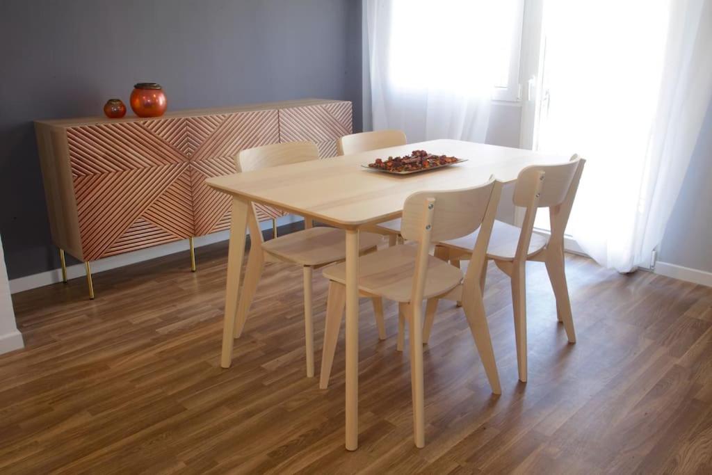 einen Esstisch mit 4 Stühlen und einem Tisch in der Unterkunft El Balcó del Bastareny Apartamento renovado 6p in Guardiola de Berga