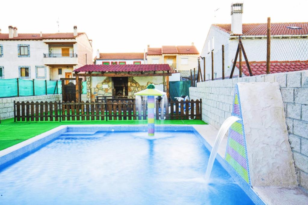 a pool with a water slide and an umbrella at El Robledillo in Robledillo