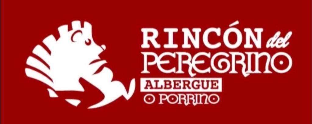 ein rotes Schild mit einem weißen Drachen auf rotem Hintergrund in der Unterkunft Albergue Rincón del Peregrino Porriño-Pleno centro-City Center in O Porriño