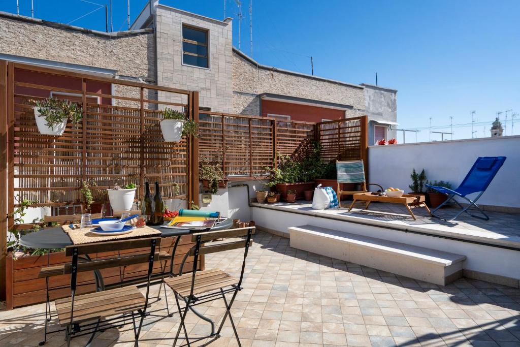 eine Terrasse mit einem Tisch, Stühlen und einem Zaun in der Unterkunft Marina Terrace Apartment in Mola di Bari