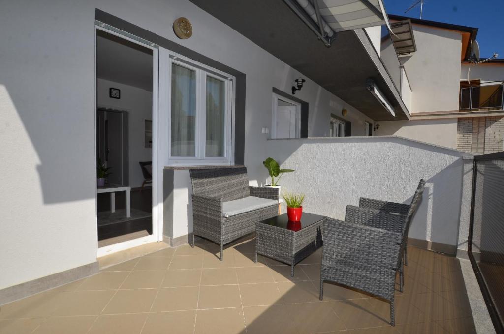 a patio with wicker chairs and a table at M&N Apartment in Rovinj