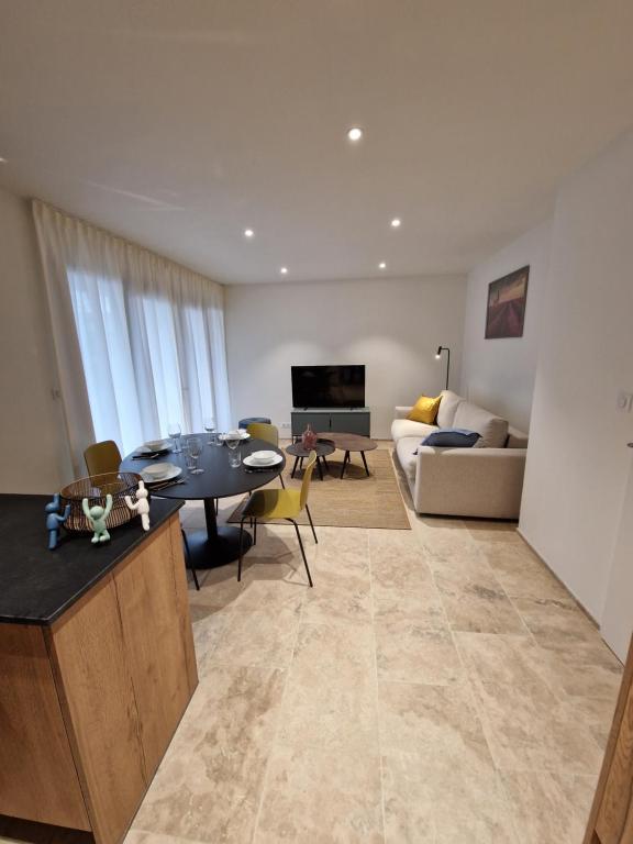 un salon avec une table et un canapé dans l'établissement Les Papillons du Ventoux - Le Souci - éénslaapkamerappartement met terras en tuin, à Malaucène