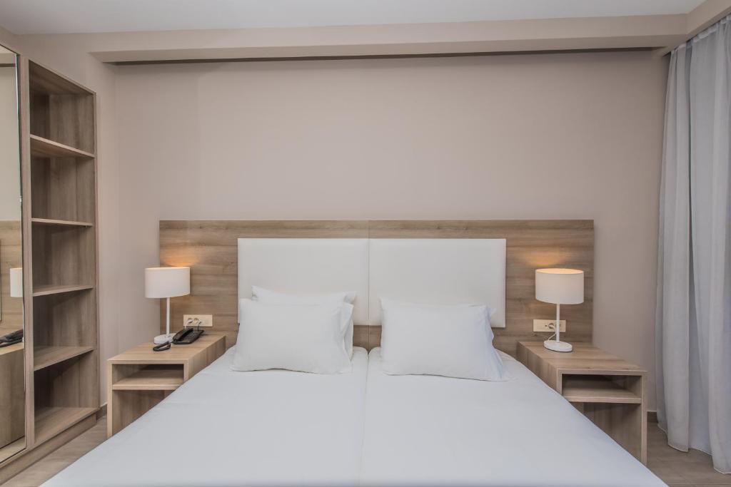 Postel nebo postele na pokoji v ubytování Porto Planos Beach Hotel