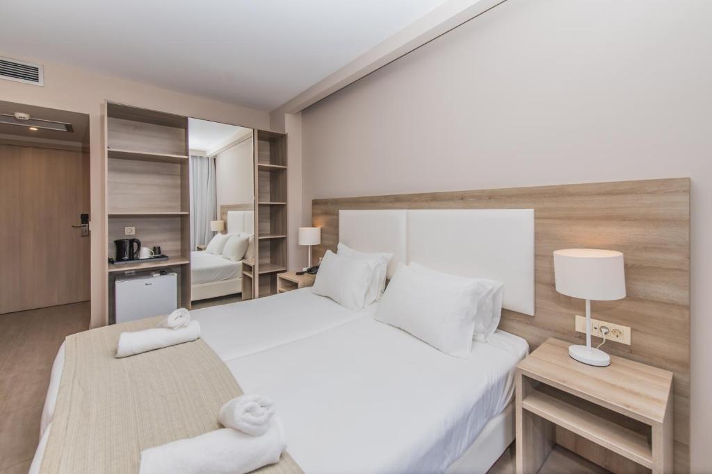 Postel nebo postele na pokoji v ubytování Porto Planos Beach Hotel