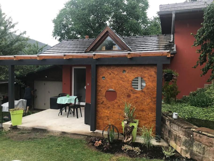 a gingerbread house with a patio in front of a house at Gîte des Renards in La Broque