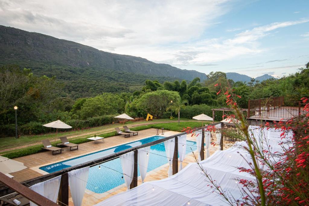 Elle offre une vue sur la piscine et les montagnes en arrière-plan. dans l'établissement Pousada Brisa da Serra, à Tiradentes