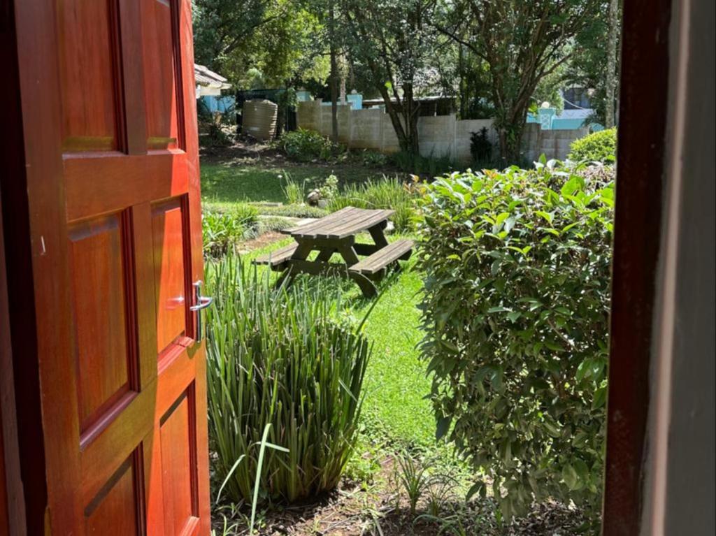 eine offene Tür zu einem Garten mit einem Picknicktisch in der Unterkunft Bogotá in Pietermaritzburg