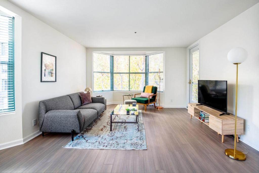 un soggiorno con un divano e una TV di S Beach 1BR w Pool Gym Shops Dining Onsite SFO-395 a San Francisco