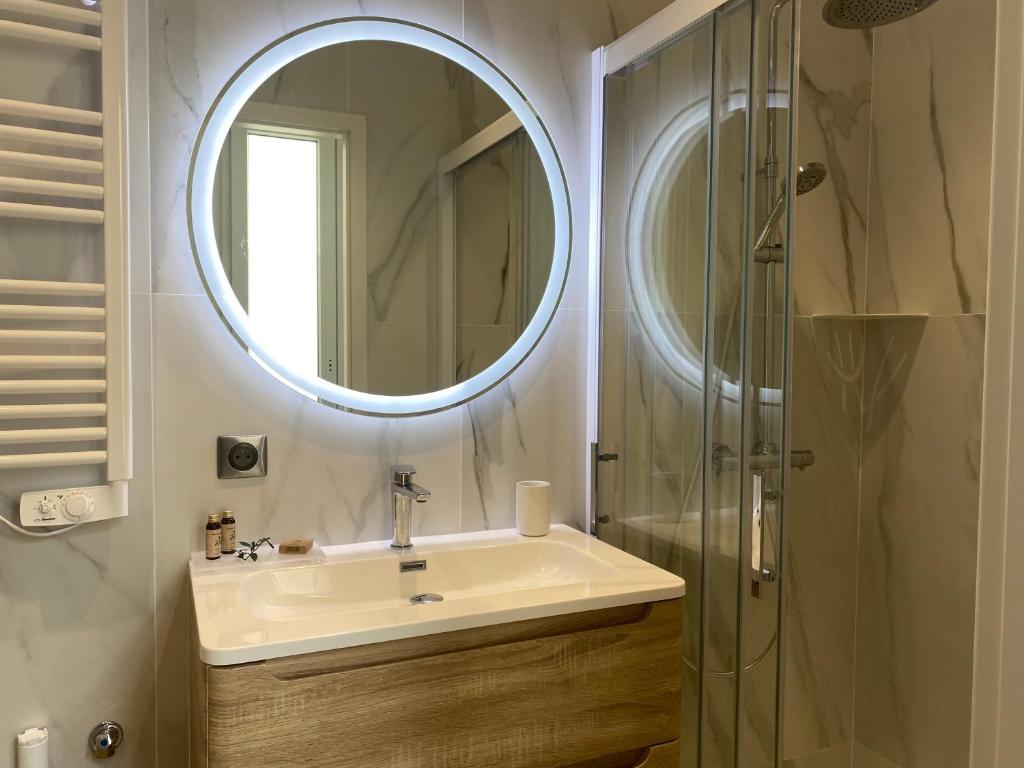 ein Bad mit einem Waschbecken und einem Spiegel in der Unterkunft Logement confortable, Nancy Thermal, Parc Ste-Marie in Nancy