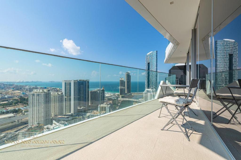 een balkon met 2 stoelen en uitzicht op de stad bij Marco Polo - Stunning 2 BR With Marina Views, Huge Pool & Gym in Dubai
