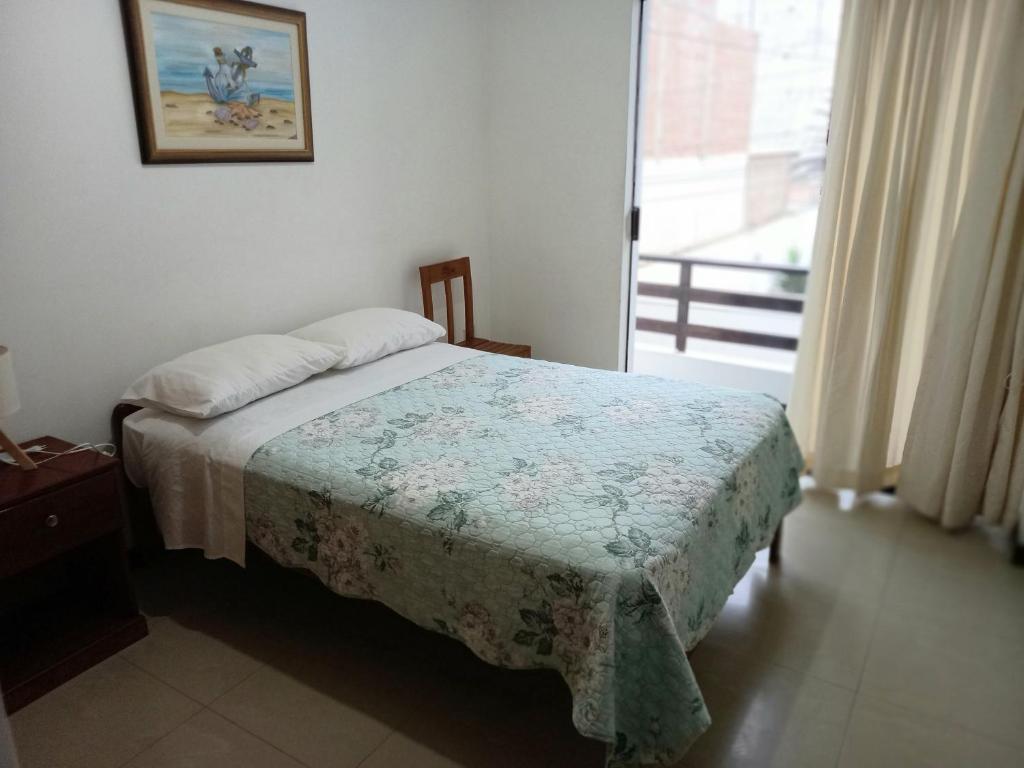 1 dormitorio con 1 cama en una habitación con ventana en Bellos Dptos Huanchaco, Perú a 50 metros del mar en Trujillo