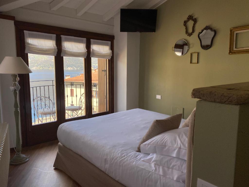 Schlafzimmer mit einem Bett und Blick auf einen Balkon in der Unterkunft Il Molo Di Hotel Villa Aurora in Lezzeno