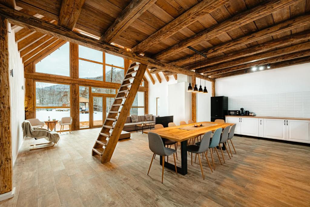 a kitchen and dining room with a wooden table and chairs at Scrind 11 - Madleine Chalet in Cluj-Napoca