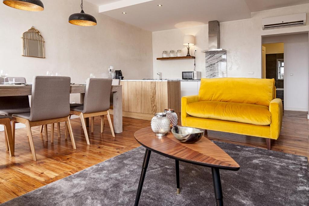 a living room with a yellow couch and a table at Olivier Premium Apartments - Downtown Lisbon in Lisbon