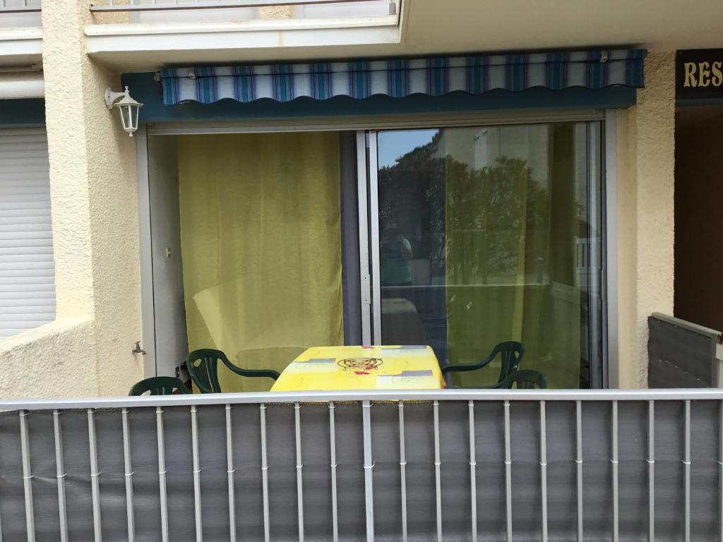 a yellow suitcase sitting on a balcony of a house at T2 St pierre la mer in Fleury