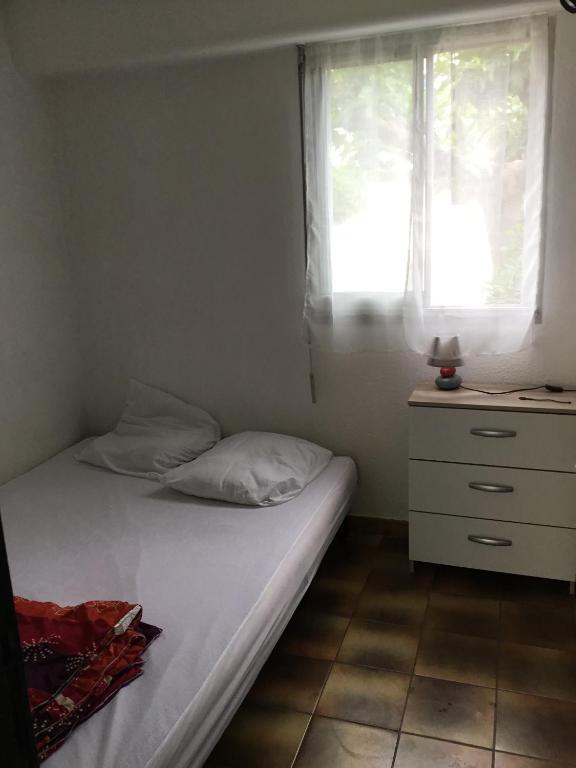 sypialnia z łóżkiem, komodą i oknem w obiekcie T2 St pierre la mer w mieście Fleury