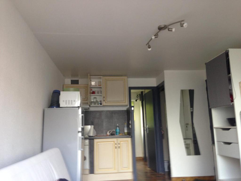 małą kuchnię z białą lodówką w pokoju w obiekcie T2 St pierre la mer w mieście Fleury