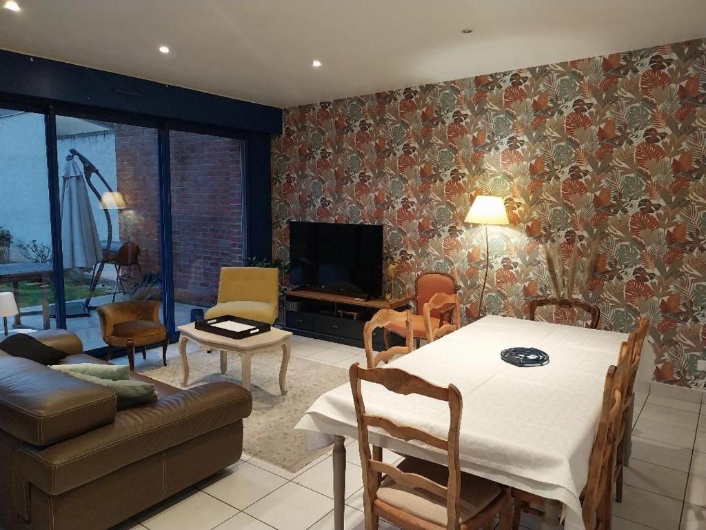 un salon avec une table et un canapé dans l'établissement La Maison de Léonie, à Péronne