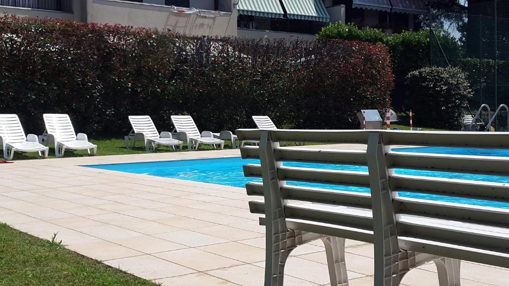 una fila de sillas junto a una piscina en MAISON MARGÙ en  Monvalle 