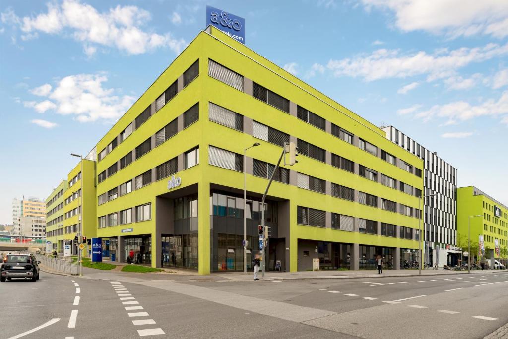 a yellow building on the corner of a street at a&o Graz Hauptbahnhof in Graz