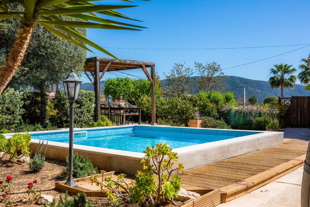 a swimming pool in a garden with a wooden deck and a swimming pool at Casa Martin in Calvià