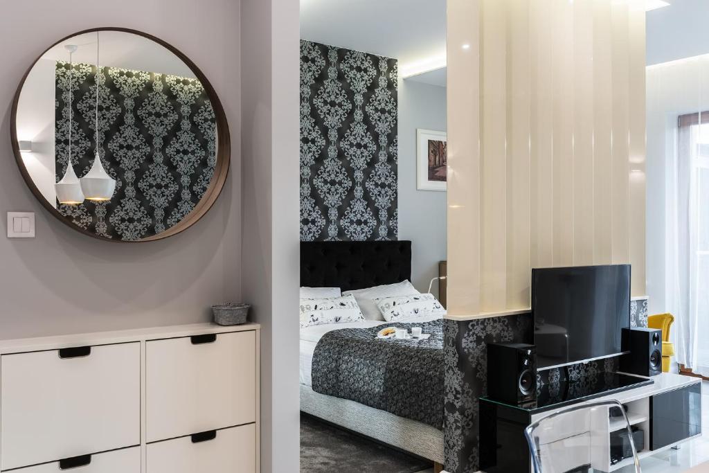 Schlafzimmer mit einem Bett und einem Spiegel in der Unterkunft White Pearl Apartment in Krakau