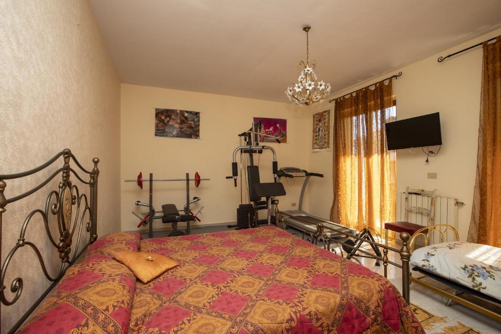 - une chambre avec un lit et une télévision dans l'établissement Casa Al Mare San Giorgio, à Gioiosa Marea
