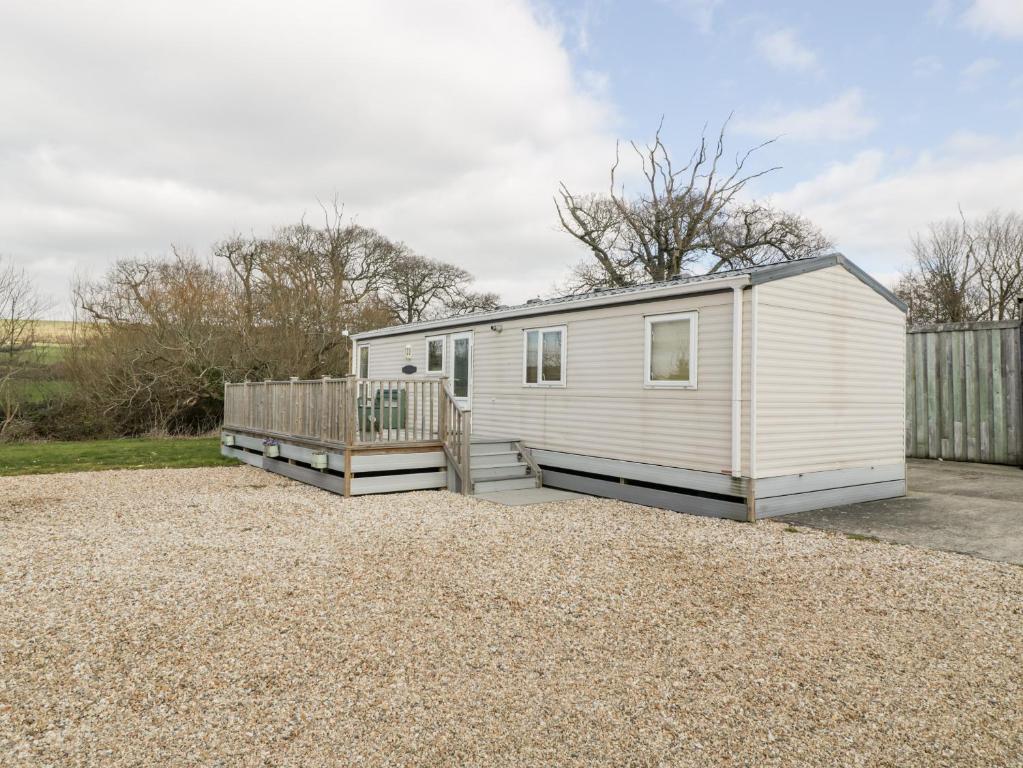 a white tiny house on a gravel lot at The Hideaway in Weymouth