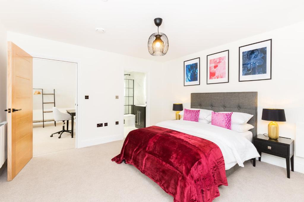 a bedroom with a large bed with a red blanket at Sydenham Place - Birmingham City Centre Jewellery Quarter - A Trio of Premium High End Town/Penthouses - 4 Bedrooms & Secure EV Parking in Birmingham