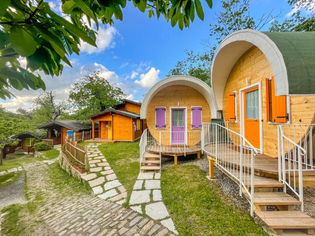 een groep huizen met oranje en paarse deuren bij Glamping Villaggio Parco Dei Castagni 4 stelle in Montecreto