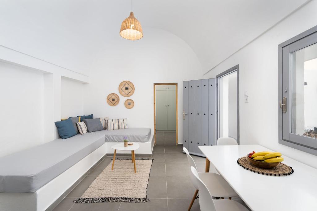 a white living room with a couch and a table at Villa Tholos & Prive Jacuzzi in Kamari