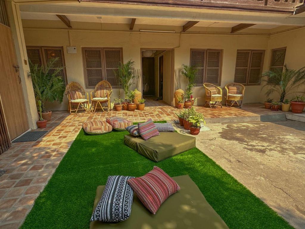 a yard with green grass and chairs and a patio at The Melo pomelo courtyard. ( Right in between Thamel and basantapur durbar square) in Kathmandu