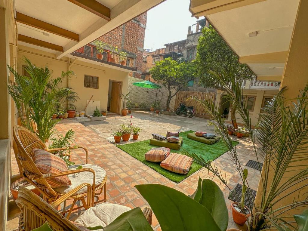 um pátio com plantas e cadeiras e um pátio em The Melo pomelo courtyard. ( Right in between Thamel and basantapur durbar square) em Catmandu