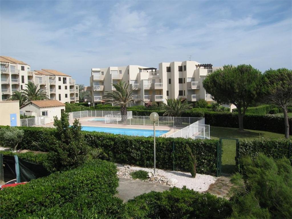 - une vue sur un complexe d'appartements avec une piscine dans l'établissement Saint-Cyprien: T2 cabine rénové 6 pers, piscine, parking, à 100m de la plage - FR-1-106-80, à Saint-Cyprien