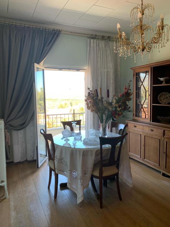 un comedor con una mesa con sillas y una lámpara de araña en Irini's House en Arménoi