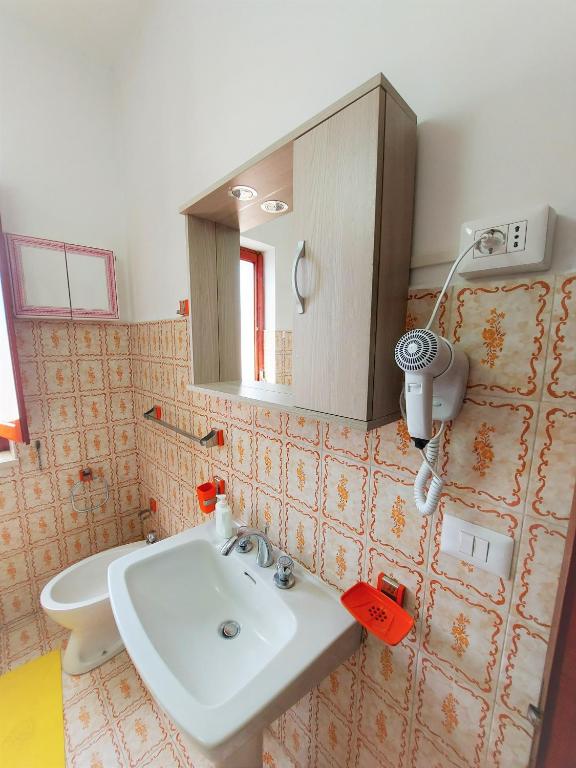 łazienka z umywalką i lustrem w obiekcie Margherita house sorrento w mieście Vico Equense