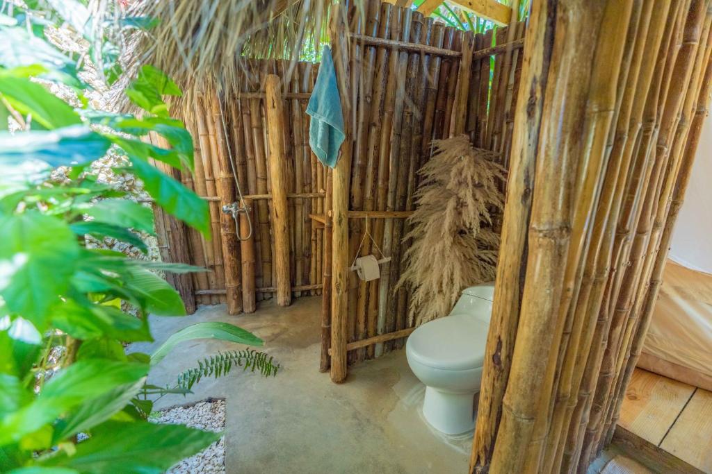 a bathroom with a toilet in a bamboo structure at Casita de Madera Encuentro in Bombita
